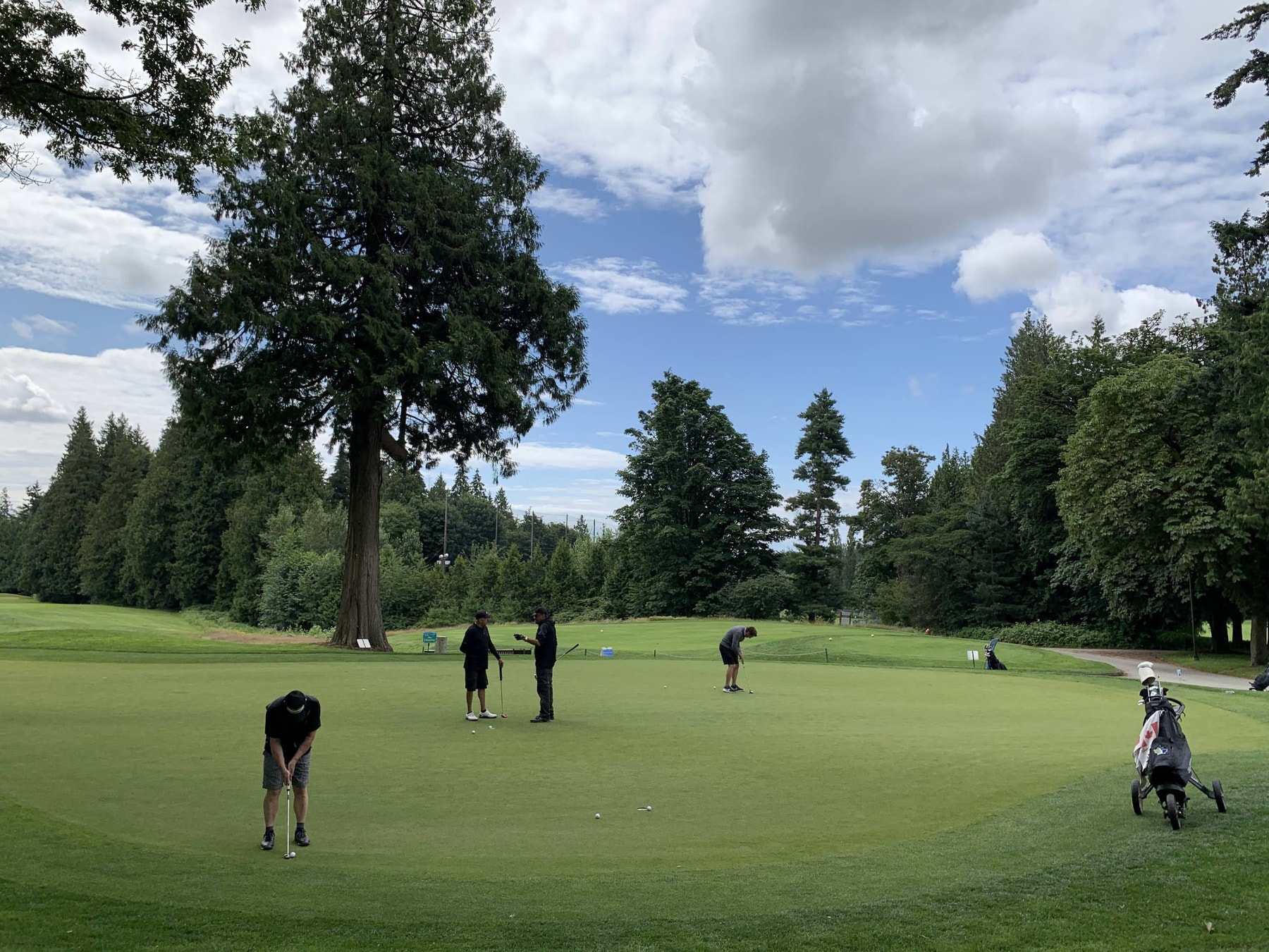 Golfers practicing their putting under a mix of clouds and blue sky-just another day at Fraserview Golf Course. Golfers practicing their putting under a mix of clouds and blue sky-just another day at Fraserview Golf Course.