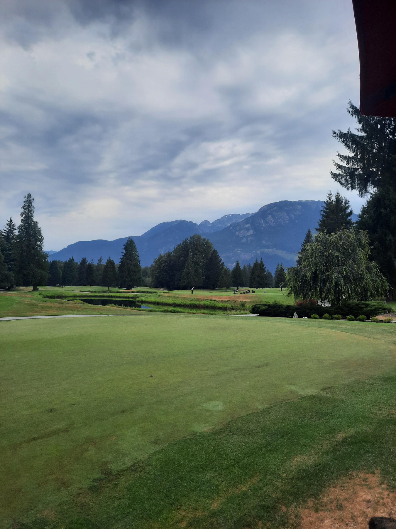 Peaceful fairway view at Fraserview Golf Course, framed by mountains and evergreens. Peaceful fairway view at Fraserview Golf Course, framed by mountains and evergreens.