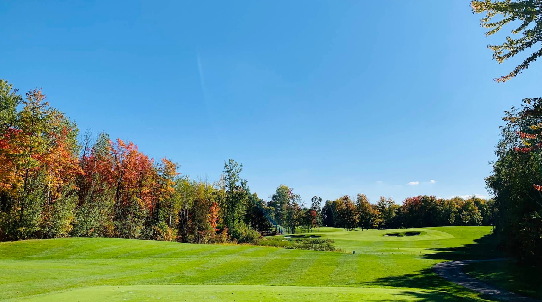 A stunning fairway view at The Royal Montreal Golf Club, framed by vibrant autumn colors under a clear blue sky. A stunning fairway view at The Royal Montreal Golf Club, framed by vibrant autumn colors under a clear blue sky.