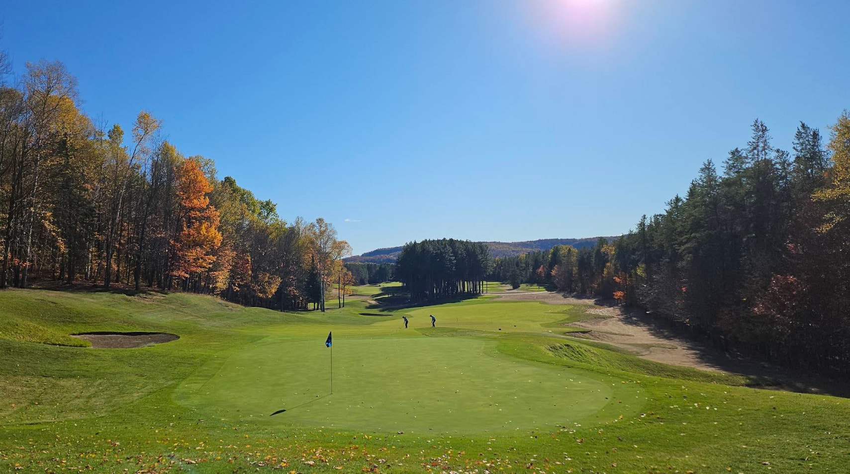 A view of Le Diable Golf Course at Mont-Tremblant, featuring wide fairways framed by autumn trees and dramatic elevation under a clear blue sky. A view of Le Diable Golf Course at Mont-Tremblant, featuring wide fairways framed by autumn trees and dramatic elevation under a clear blue sky.