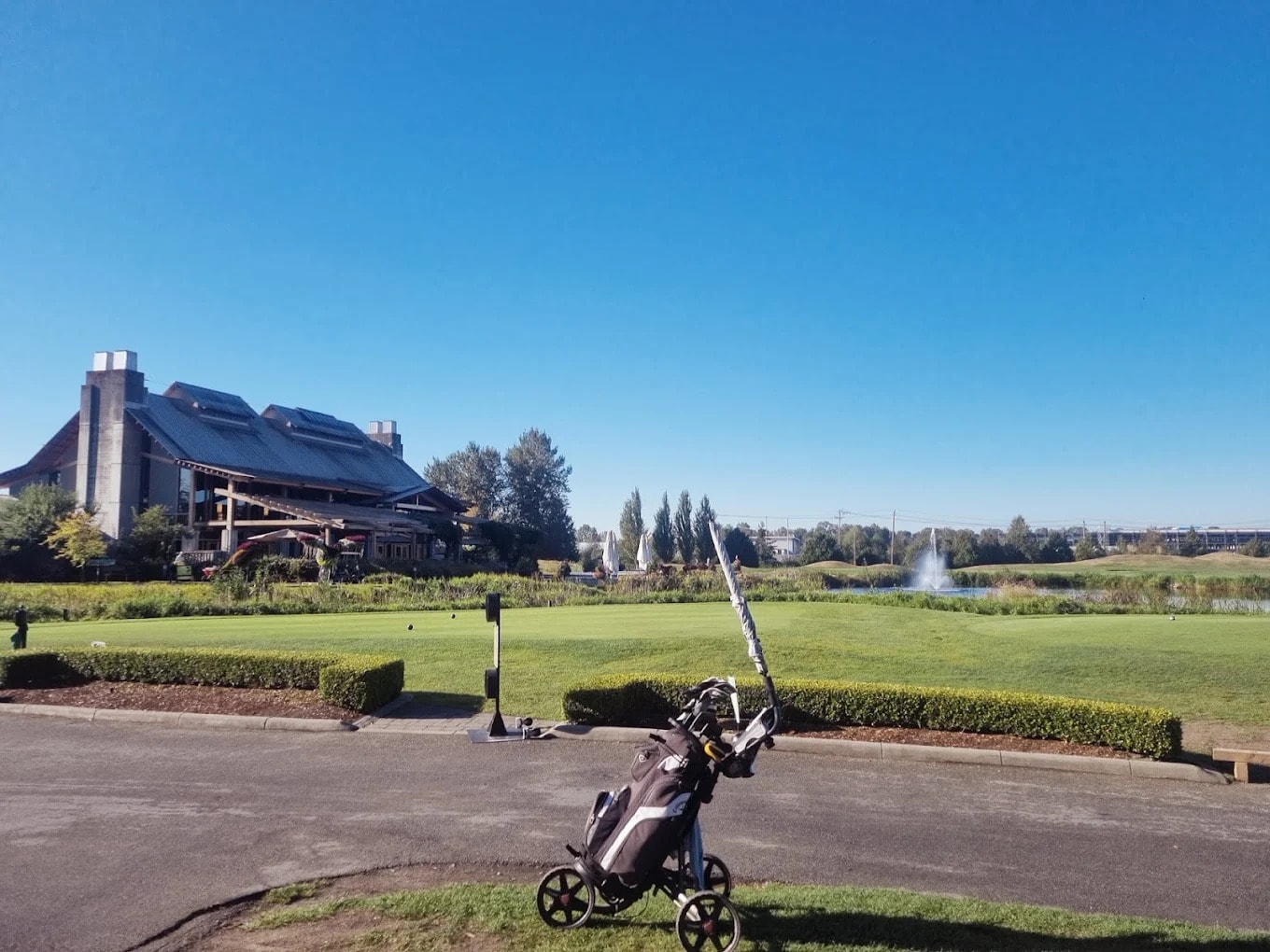 View of Riverway’s timber-framed clubhouse and fountain from the first tee—where your round begins with a postcard backdrop. View of Riverway’s timber-framed clubhouse and fountain from the first tee—where your round begins with a postcard backdrop.